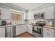 Bright kitchen with white cabinets, stainless steel appliances, and granite countertops at 5275 Willow Links # 50, Sarasota, FL 34235