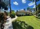 Charming single story home with a well-manicured lawn and walkway surrounded by lush tropical landscaping at 5378 Royal Palm Ave # 5378, Sarasota, FL 34234