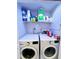 Laundry room with modern washer and dryer units and storage shelves at 5378 Royal Palm Ave # 5378, Sarasota, FL 34234