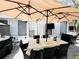 Cozy backyard patio with shade umbrella, dining set, and outdoor TV for outdoor entertainment at 5378 Royal Palm Ave # 5378, Sarasota, FL 34234