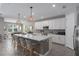 Spacious kitchen featuring a large island with seating, sleek cabinetry, and stainless steel appliances at 5621 Badini Way, Palmetto, FL 34221