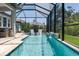 The screened pool features in-pool seating and a serene blue tile water feature for luxurious relaxation at 5621 Badini Way, Palmetto, FL 34221