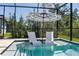 A screened pool features in-pool loungers and umbrella, offering the perfect place to unwind at 5621 Badini Way, Palmetto, FL 34221