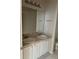 Bathroom with a double vanity, white cabinets, a large mirror, and a white sink at 5681 Bentgrass Dr # 13-201, Sarasota, FL 34235
