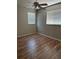 Bedroom with wood-look floors, two windows with blinds, and neutral colored walls at 5681 Bentgrass Dr # 13-201, Sarasota, FL 34235