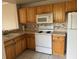 Kitchen featuring wooden cabinets, and white appliances, perfect for meal preparation at 5681 Bentgrass Dr # 13-201, Sarasota, FL 34235