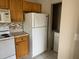 Functional kitchen with wooden cabinets and white appliances, overlooking the laundry area at 5681 Bentgrass Dr # 13-201, Sarasota, FL 34235