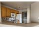 Functional kitchen with wooden cabinets and white appliances, overlooking the living area at 5681 Bentgrass Dr # 13-201, Sarasota, FL 34235