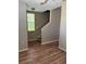 Inviting living room showcasing wood-look floors, a staircase, and a window for ample natural light at 5681 Bentgrass Dr # 13-201, Sarasota, FL 34235