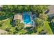 Aerial view of a luxurious community pool and spa area with lounge chairs, lush landscaping, and sunny skies at 5688 Pipers Waite # 50, Sarasota, FL 34235