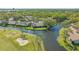 Stunning aerial view of golf course home with waterfront views, surrounded by lush landscaping and mature trees at 5688 Pipers Waite # 50, Sarasota, FL 34235