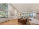 Spacious living room with vaulted ceilings, hardwood floors, and large windows overlooking the waterfront at 5688 Pipers Waite # 50, Sarasota, FL 34235