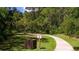 Scenic view of a paved nature trail, lush greenery, and a wooden trash receptacle at 5688 Pipers Waite # 50, Sarasota, FL 34235