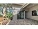 Cozy outdoor patio with brick pavers, a wooden bench, and a view through sliding doors into the home at 5688 Pipers Waite # 50, Sarasota, FL 34235