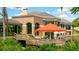 Exterior view of waterfront dining with a covered seating area and manicured landscaping at 5688 Pipers Waite # 50, Sarasota, FL 34235