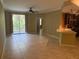 Open-concept living room featuring tile floors, ceiling fan, and sliding glass doors to a balcony at 5691 Bentgrass Dr # 15-102, Sarasota, FL 34235