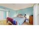 Bright bedroom featuring blue walls, hardwood flooring, and a comfortable wrought iron bed at 6342 7Th W Ave # 6342, Bradenton, FL 34209