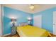 Bright bedroom featuring blue walls, ceiling fan, hardwood floors, and bedside lamps at 6342 7Th W Ave # 6342, Bradenton, FL 34209