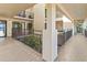 Hallway with dark metal railing and neutral walls leads to an outdoor scene with a view of trees at 6460 Mourning Dove Dr # 204, Bradenton, FL 34210
