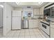 Well-lit kitchen featuring tile floors, white cabinetry, and stainless steel appliances at 6460 Mourning Dove Dr # 204, Bradenton, FL 34210