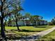 Scenic exterior view of the condo building surrounded by mature trees and an expansive lawn at 6505 Stone River Rd # 306, Bradenton, FL 34203