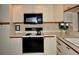 Well-lit kitchen featuring white cabinets, a black oven, and ample counter space at 6505 Stone River Rd # 306, Bradenton, FL 34203