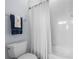 A well-lit, tiled bathroom including a toilet, shower, and towel rack with hanging towels at 6637 Taeda Dr, Sarasota, FL 34241