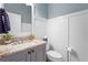 Updated bathroom features a granite countertop, vanity, toilet, and wainscoting at 6637 Taeda Dr, Sarasota, FL 34241