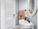 Cozy bathroom featuring a pedestal sink, decorative mirror, soft towels, and natural light from an adjacent doorway at 6637 Taeda Dr, Sarasota, FL 34241