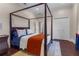 Primary bedroom with a four-poster bed, rug, and closet doors at 6637 Taeda Dr, Sarasota, FL 34241