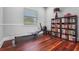 Bright home gym featuring workout machine, hardwood floors and built-in bookshelf at 6637 Taeda Dr, Sarasota, FL 34241