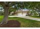 Property featuring a three-car garage, complemented by mature trees and lush greenery at 6637 Taeda Dr, Sarasota, FL 34241