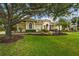 Elegant home featuring lush landscaping, a well-manicured lawn, and mature trees providing ample shade at 6637 Taeda Dr, Sarasota, FL 34241