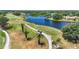 Scenic golf course with a lake, golf carts on the path and three palm trees at 6637 Taeda Dr, Sarasota, FL 34241