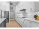Modern kitchen boasts white cabinets, stainless steel appliances, and ample counter space at 6637 Taeda Dr, Sarasota, FL 34241