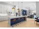 Open-concept kitchen boasts white cabinets, a large island with seating, and modern pendant lighting at 6637 Taeda Dr, Sarasota, FL 34241