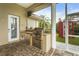 Outdoor kitchen area with grill, refrigerator, and storage, adjacent to a backyard play structure at 6637 Taeda Dr, Sarasota, FL 34241