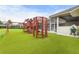 A wooden playground in a backyard features a climbing wall, swings, a slide, and a rope climbing structure at 6637 Taeda Dr, Sarasota, FL 34241
