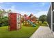 A backyard wooden playground with climbing wall, swings, slide, and rope ladder on artificial turf at 6637 Taeda Dr, Sarasota, FL 34241