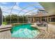Sparkling pool with a spillover spa, surrounded by a screened enclosure and lush landscaping at 6637 Taeda Dr, Sarasota, FL 34241