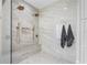 Spa-like shower with dual showerheads, marble-look tile, and a built-in bench, complemented by bronze fixtures and decor at 6637 Taeda Dr, Sarasota, FL 34241