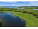 Scenic aerial view of a golf course, lakes, and lush green vegetation along the coastline at 7015 River Hammock Dr # 204, Bradenton, FL 34212