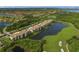 A gorgeous aerial shot showcases condos beside a lake, surrounded by golf course greens and lush greenery at 7015 River Hammock Dr # 204, Bradenton, FL 34212