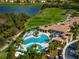 A stunning aerial view of the community pool and dining area, set amidst a golf course and lush landscaping at 7015 River Hammock Dr # 204, Bradenton, FL 34212