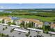 Aerial view of waterfront condo buildings, palm trees, parking, and picturesque water views at 7015 River Hammock Dr # 204, Bradenton, FL 34212