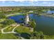 Scenic aerial view of a lighthouse nestled on a lake, complete with walking trails and picturesque landscaping at 7015 River Hammock Dr # 204, Bradenton, FL 34212