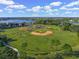 Aerial view of a well-maintained baseball field with lush green grass, a lake, and surrounding trees at 7015 River Hammock Dr # 204, Bradenton, FL 34212
