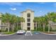 Exterior of condo building with palm trees, covered parking, and accessible parking spots at 7015 River Hammock Dr # 204, Bradenton, FL 34212