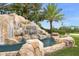 A grand entrance featuring a waterfall with the River Strand sign surrounded by lush tropical landscaping at 7015 River Hammock Dr # 204, Bradenton, FL 34212