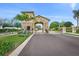 A gated community entrance featuring lush landscaping and an elegant stone entryway at 7015 River Hammock Dr # 204, Bradenton, FL 34212